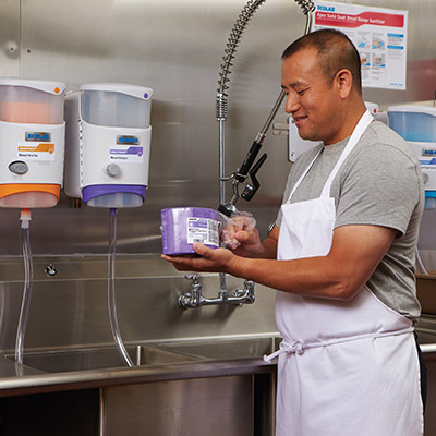 Installing cleaning chemical dispensers in a commercial kitchen.
