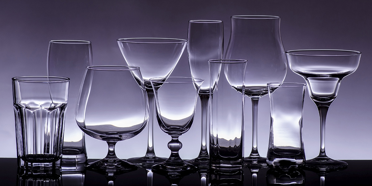 Assorted bar glasses on a blue background